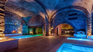 Thermal water pools at the In Acqua Veritas SPA, with historic architecture, sophisticated lighting and a relaxing atmosphere.