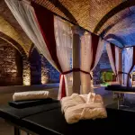 Sala de preparación con camillas de masaje, albornoces y toallas alineados, reflejo de la exclusividad y la atención al detalle del spa In Acqua Veritas.