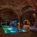 Un interior con arcos y detalles clásicos en el balneario In Acqua Veritas, que evoca el encanto intemporal de los antiguos baños romanos.