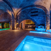 Espaço de banho com colunas e reflexos dourados no In Acqua Veritas, evocando o requinte das termas romanas em Évora.