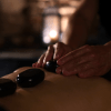 Cliente numa sessão de massagem com pedras quentes no In Acqua Veritas Spa, representando o bem-estar e o luxo exclusivo em Évora.