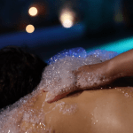 Una terapeuta realiza un cremoso baño de burbujas a una clienta en el balneario In Acqua Veritas, que ofrece un ritual lujoso y sensorial en Évora.