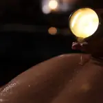 Un terapeuta aplica cera caliente de vela en la espalda de un cliente en el spa In Acqua Veritas, en un ritual personalizado de lujo y bienestar.