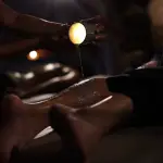 Una terapeuta aplica cera caliente de vela en las piernas de una clienta en el balneario In Acqua Veritas, en una exclusiva experiencia sensorial en Évora.